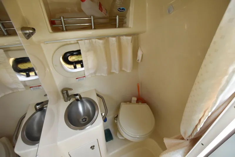 Slide: The Image of Compact bathroom in 2015 Sea Ray 260 Sundancer with sink, toilet, and storage. - 17