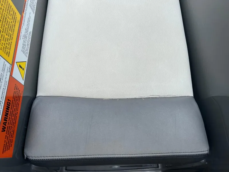 Slide: The Image of 2017 Tigé R21 boat seat with visible wear and warning labels. - 10