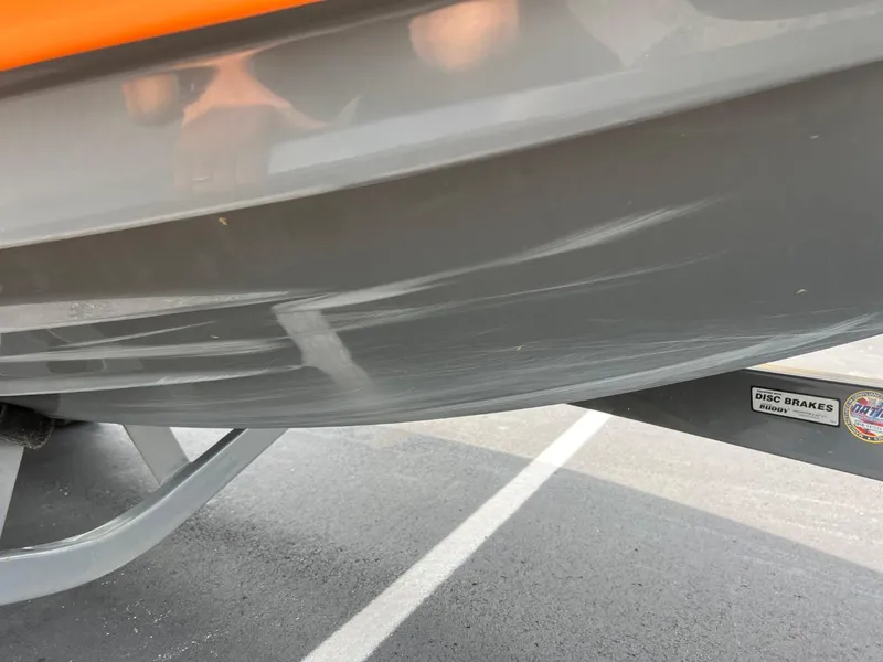 Slide: The Image of 2017 Tigé R21 boat with visible hull scratches on a trailer. - 18