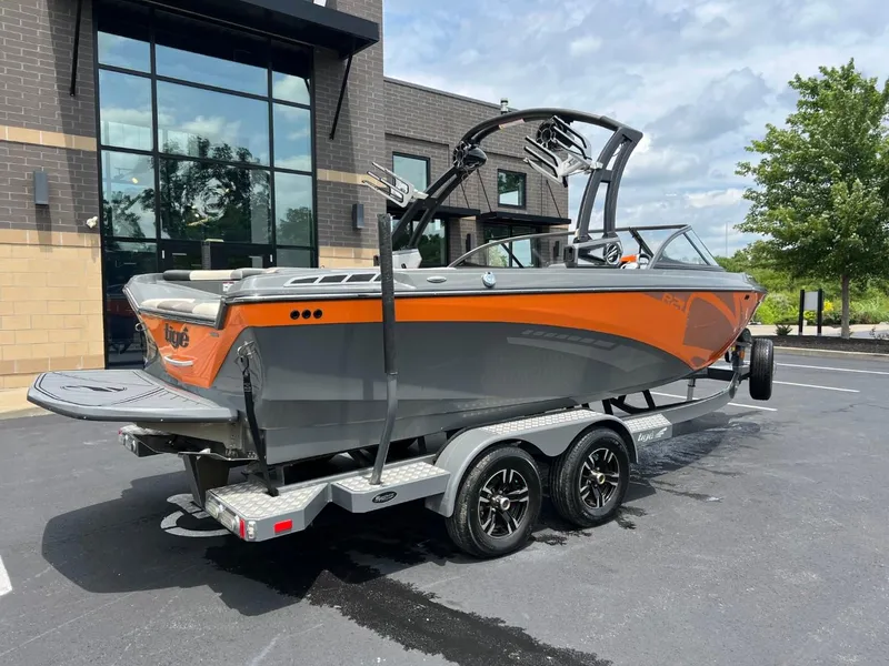 Slide: The Image of 2017 Tigé R21 boat on a trailer, parked outside a modern building. - 3