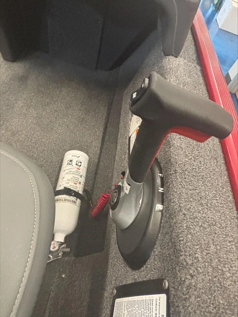 Slide: The Image of 2024 Tracker BT CLASSIC XL boat throttle and fire extinguisher on carpeted floor. - 7