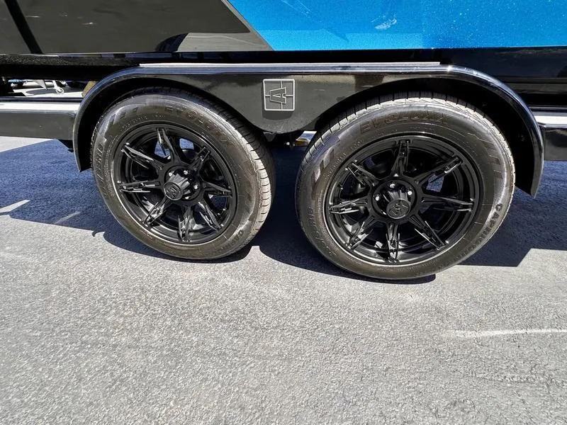 Slide: The Image of 2024 Axis A225 trailer with sleek black wheels on a sunny day. - 3