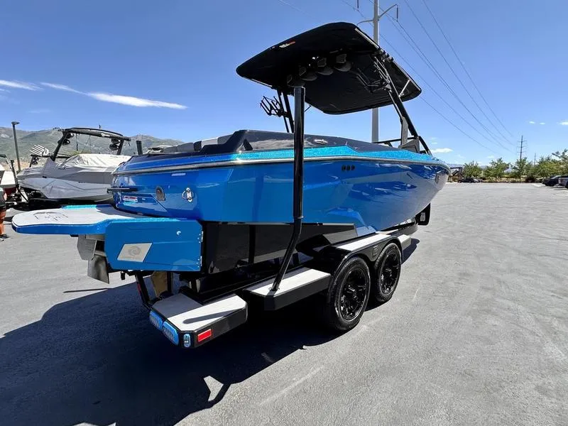 Slide: The Image of 2024 Axis A225 boat in vibrant blue on a trailer, under clear skies. - 5