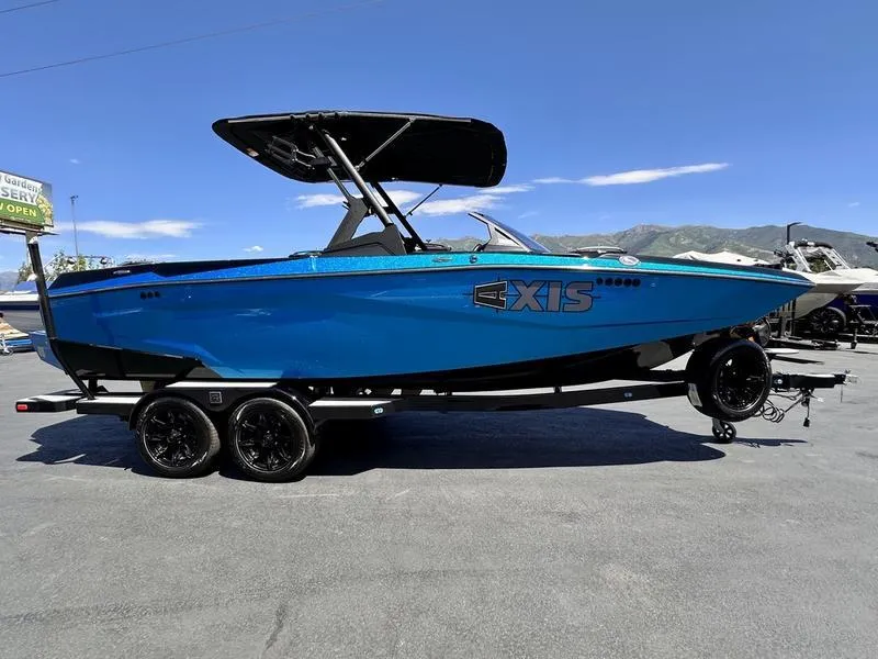 Slide: The Image of 2024 Axis A225 boat in vibrant blue on a trailer, under clear skies. - 6