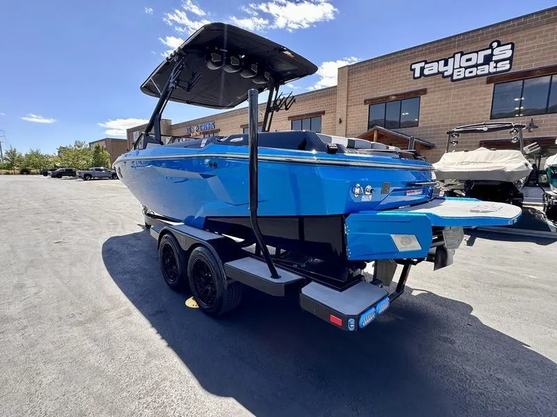 Slide: The Image of 2024 Axis A225 boat in vibrant blue, parked outside Taylor's Boats dealership. - 9