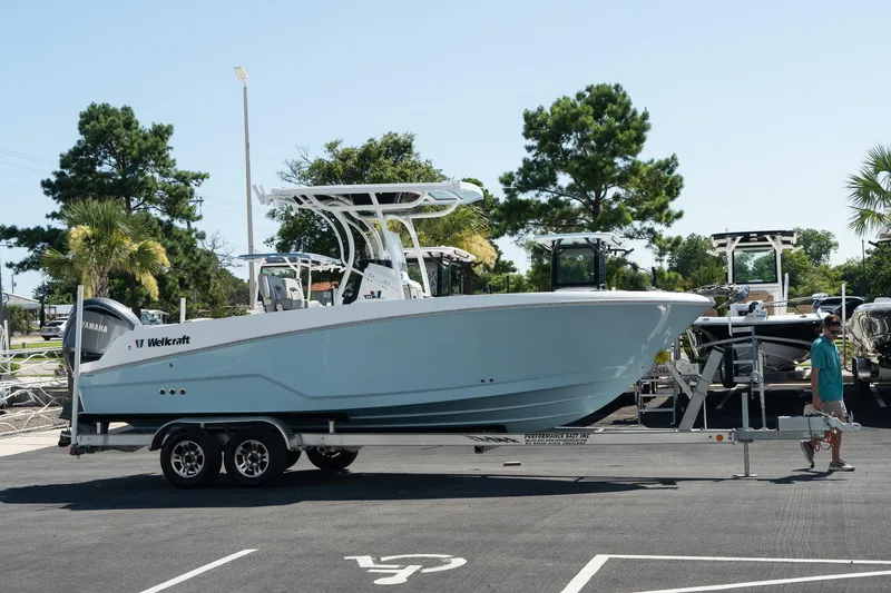 The Image of 2023 Wellcraft 242 Fisherman boat on a trailer in a parking lot. - 1