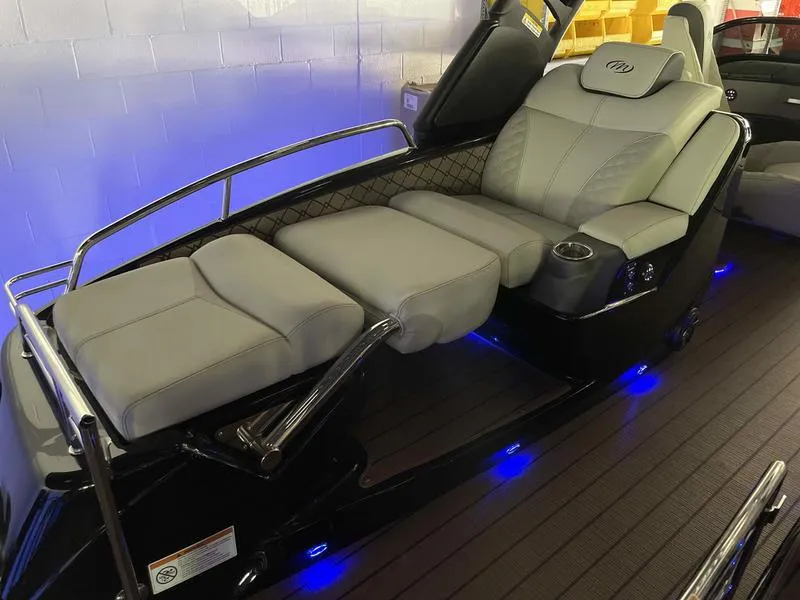 Slide: The Image of 2024 Manitou 25 LX SRW Dual Engine boat with luxurious seating and blue LED lighting. - 10