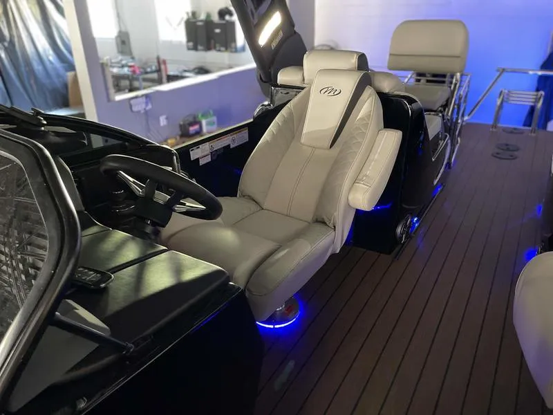 Slide: The Image of 2024 Manitou 25 LX SRW Dual Engine boat interior with luxurious seating and modern dashboard. - 7