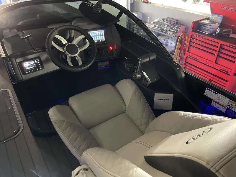 Slide: The Image of 2024 Manitou 25 LX SRW Dual Engine boat cockpit with modern controls and comfortable seating. - 8