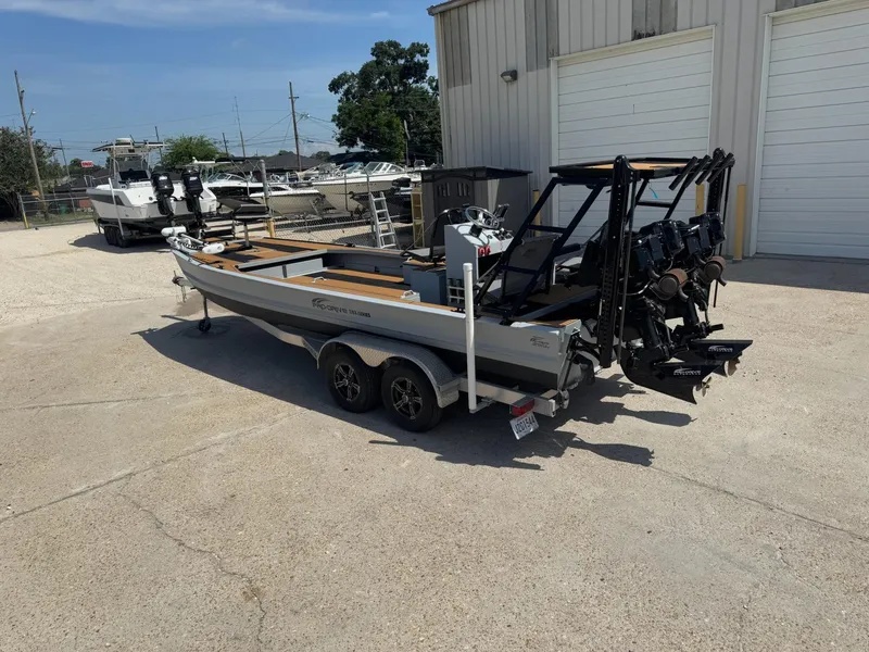 Slide: The Image of 2023 Pro-Drive 22x72 SBX boat on trailer, parked outside a warehouse. - 14