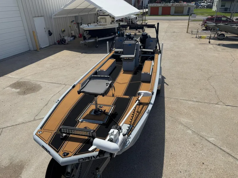 Slide: The Image of 2023 Pro-Drive 22x72 SBX boat with sleek deck design in a marina setting. - 17