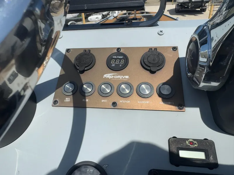 Slide: The Image of Control panel of 2023 Pro-Drive 22x72 SBX boat with voltage display and accessory switches. - 30