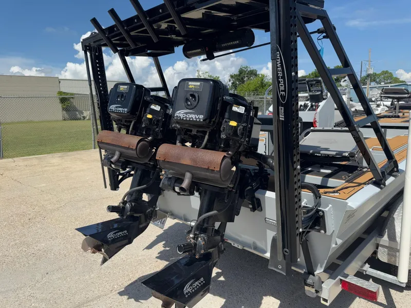 Slide: The Image of 2023 Pro-Drive 22x72 SBX boat with dual outboard motors, parked outdoors. - 36