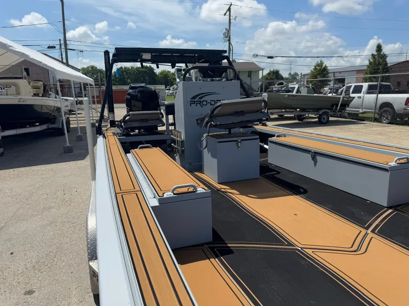 Slide: The Image of 2023 Pro-Drive 22x72 SBX boat with spacious deck and seating, displayed outdoors. - 39