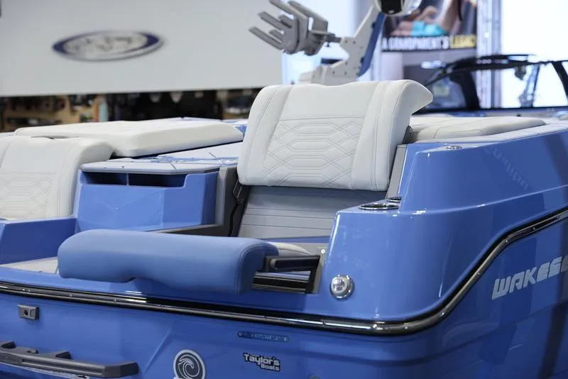 Slide: The Image of 2024 Malibu 26 LSV boat, blue exterior, white seating, rear view. - 12