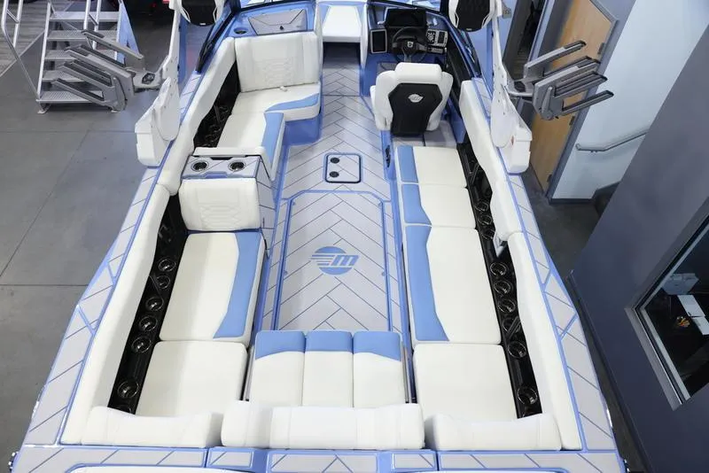Slide: The Image of 2024 Malibu 26 LSV boat interior with white and blue seating, spacious layout. - 13