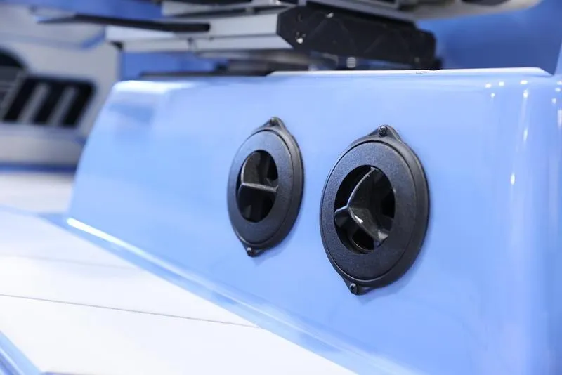 Slide: The Image of Close-up of 2024 Malibu 26 LSV boat's blue exterior with dual black vents. - 14