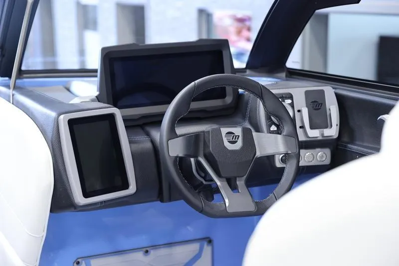 Slide: The Image of 2024 Malibu 26 LSV boat dashboard with modern steering wheel and digital displays. - 16