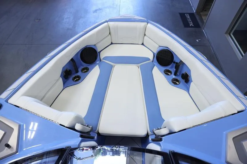 Slide: The Image of 2024 Malibu 26 LSV boat interior with white and blue seating. - 17