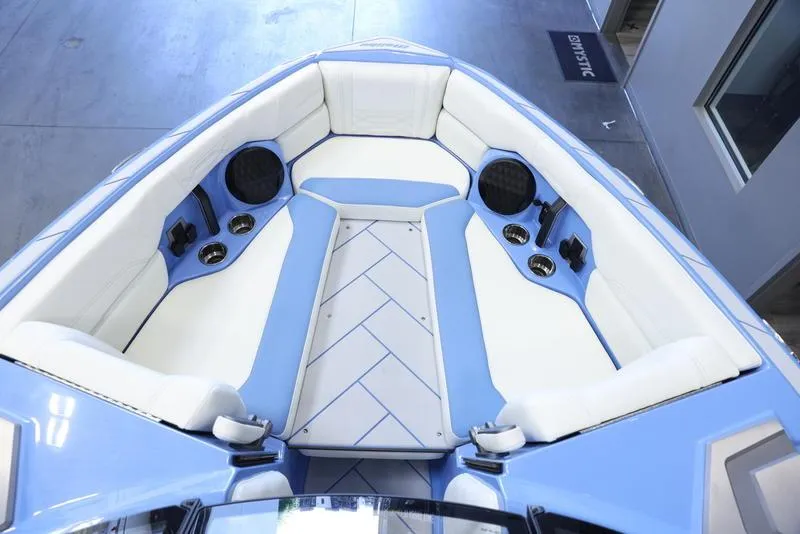 Slide: The Image of 2024 Malibu 26 LSV boat interior with blue and white seating. - 18