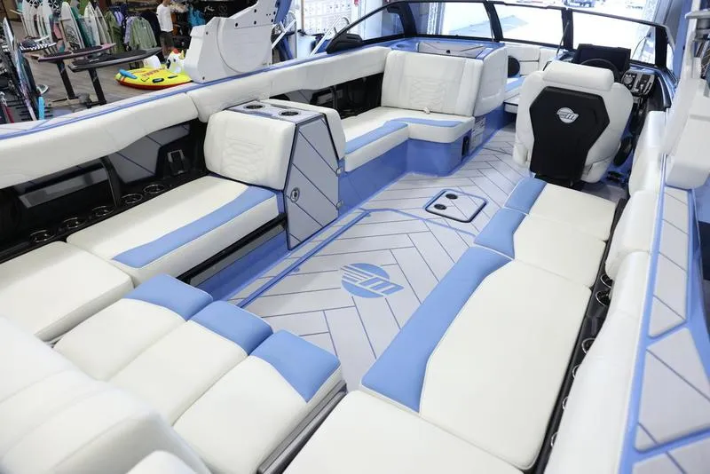 Slide: The Image of 2024 Malibu 26 LSV boat interior with white and blue seating. - 20