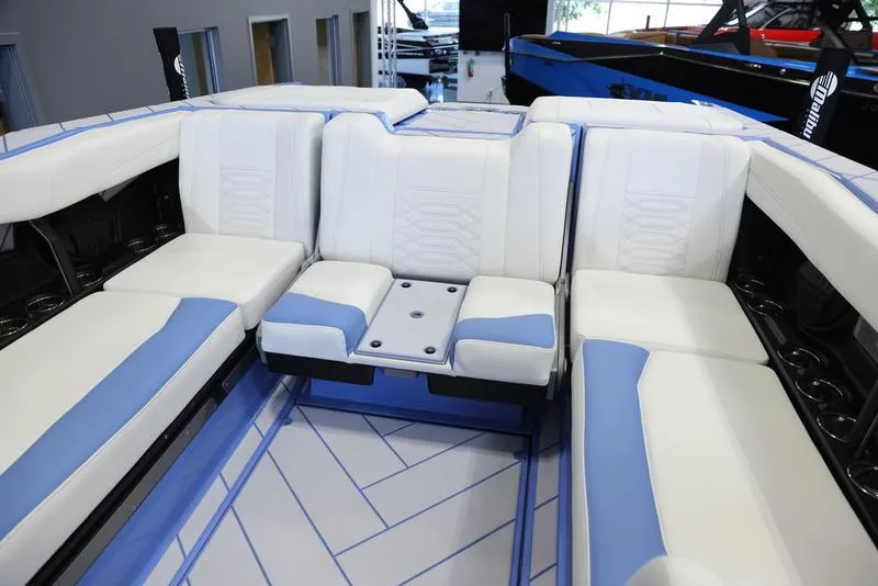 Slide: The Image of 2024 Malibu 26 LSV boat interior with white and blue seating. - 24