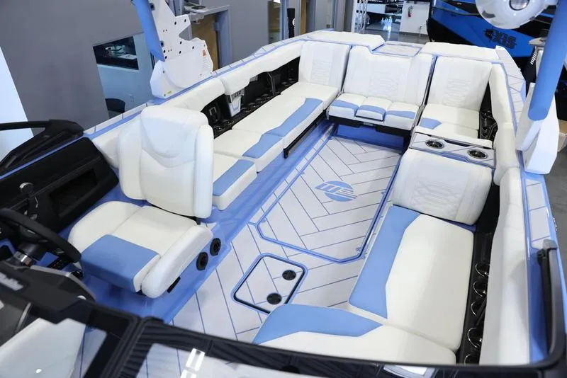 Slide: The Image of 2024 Malibu 26 LSV boat interior with white and blue seating. - 25