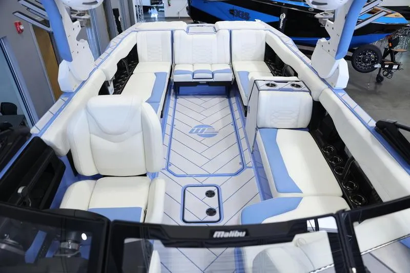 Slide: The Image of 2024 Malibu 26 LSV boat interior with white and blue seating. - 26