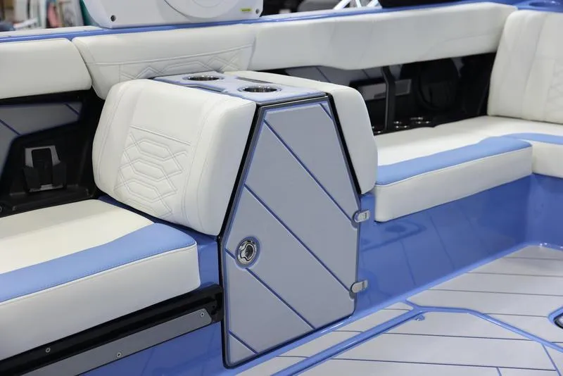 Slide: The Image of 2024 Malibu 26 LSV boat interior with white and blue seating and storage compartment. - 28