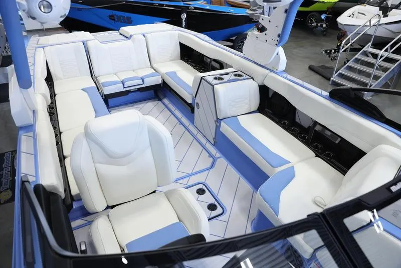 Slide: The Image of 2024 Malibu 26 LSV boat interior with white and blue seating. - 29