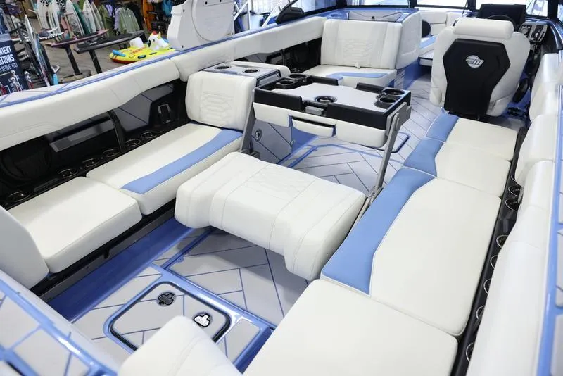 Slide: The Image of 2024 Malibu 26 LSV boat interior with white and blue seating, modern design. - 31