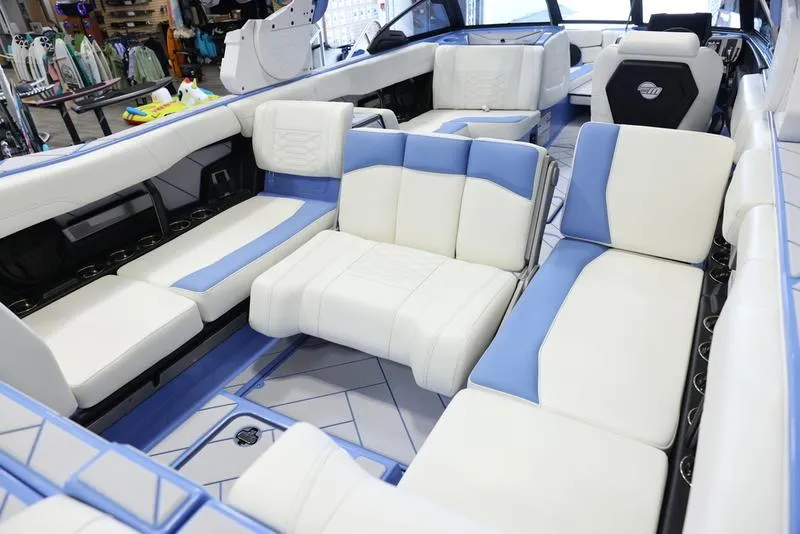 Slide: The Image of 2024 Malibu 26 LSV boat interior with white and blue seating. - 32