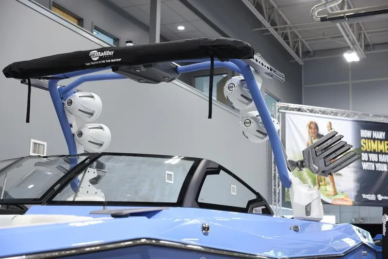Slide: The Image of 2024 Malibu 26 LSV boat with wakeboard tower and speakers in showroom. - 7