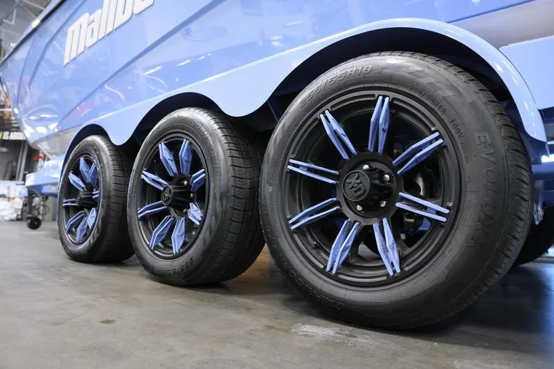 Slide: The Image of 2024 Malibu 26 LSV boat trailer with custom blue and black wheels. - 8
