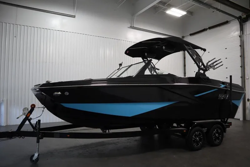 Slide: The Image of 2024 Heyday H22 boat in black and blue, displayed indoors on a trailer. - 17