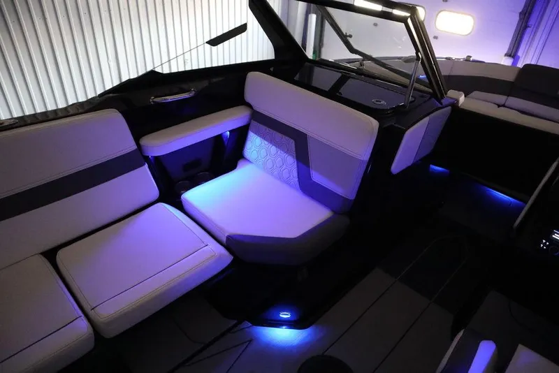 Slide: The Image of 2024 Heyday H22 boat interior with ambient blue LED lighting and cushioned seating. - 38