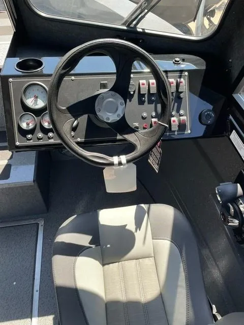Slide: The Image of 2024 Spartan 220 Maximus boat cockpit with steering wheel and control panel. - 12