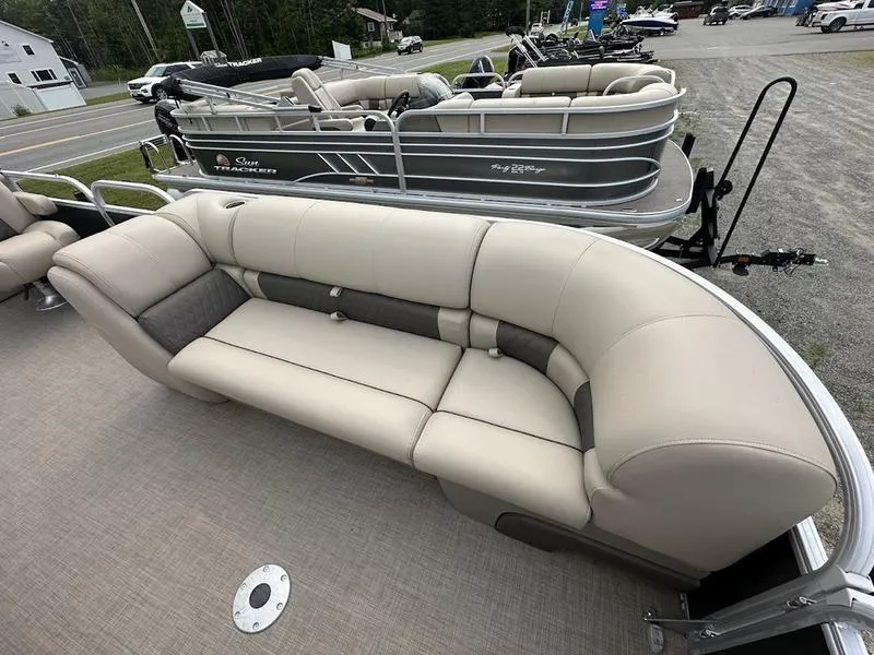 Slide: The Image of 2021 Sun Tracker PB 24 DLX pontoon boat with beige seating and spacious deck. - 4
