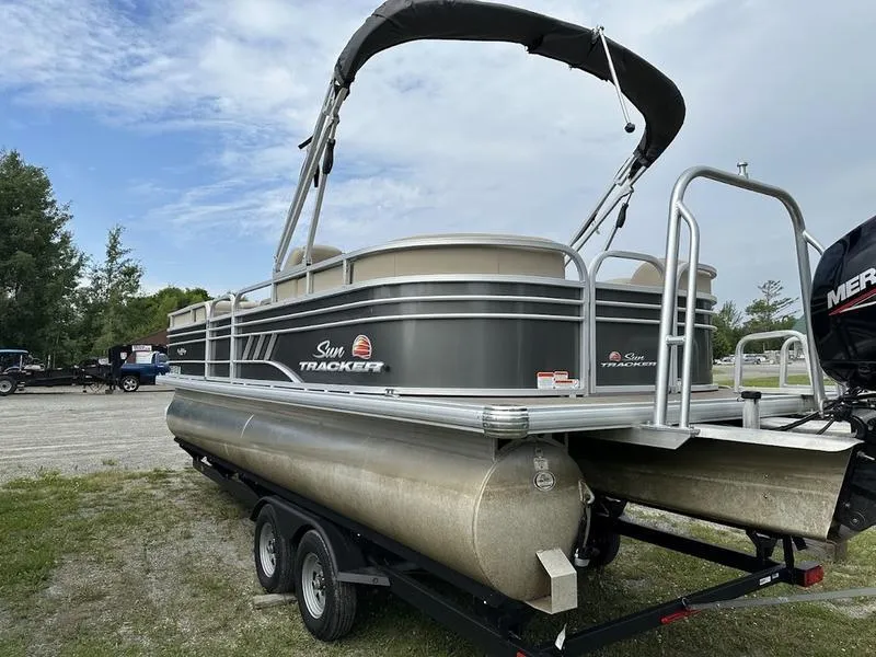 Slide: The Image of 2021 Sun Tracker PB 24 DLX pontoon boat on trailer, parked outdoors. - 9