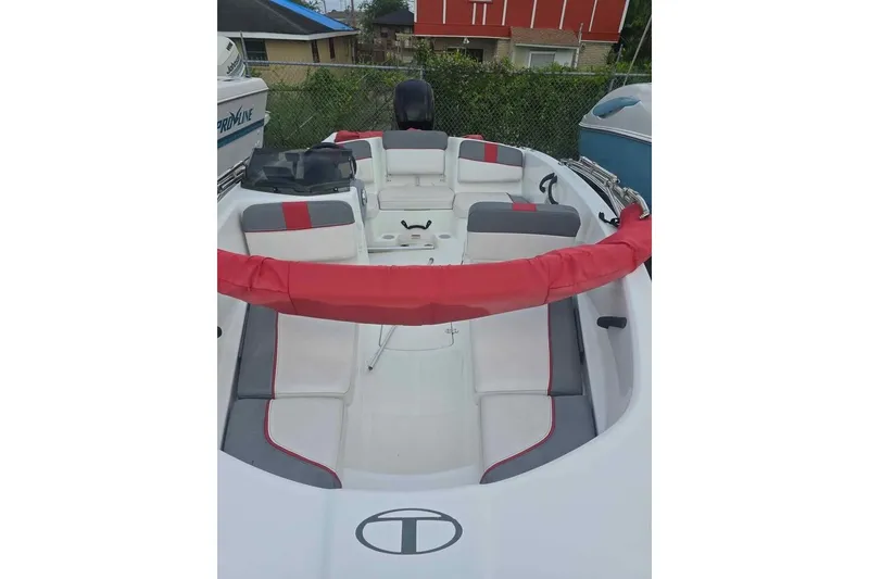 Slide: The Image of 2020 Tahoe T16 boat interior with red and gray seating, parked outdoors. - 5