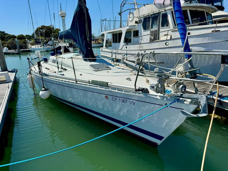 Slide: The Image of 1988 Beneteau First Class 12 sailboat in marina, calm waters, clear sky. - 0