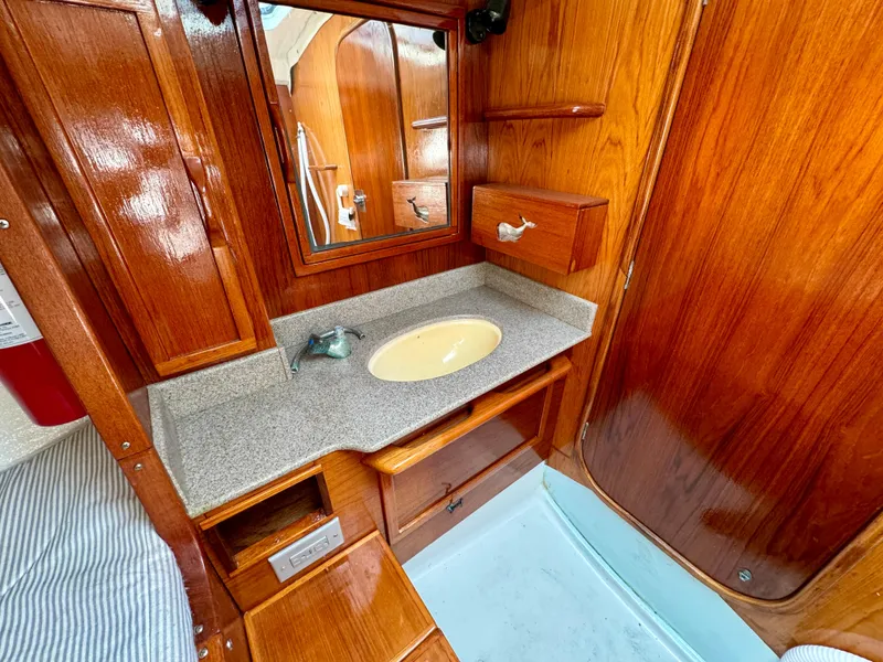 Slide: The Image of 1988 Beneteau First Class 12 yacht interior with wooden table, striped seating, and nautical decor. - 15