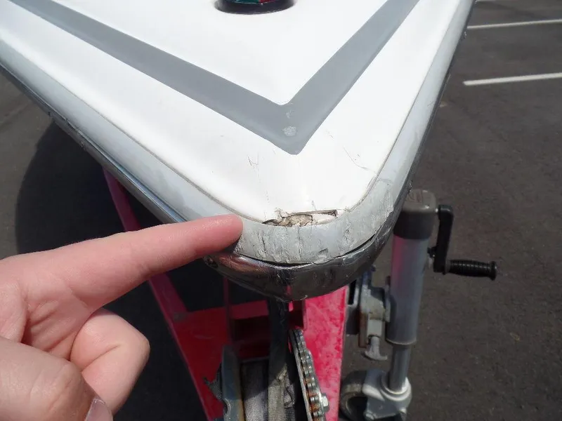 Slide: The Image of Damaged bow of a 2003 Supra 21 boat with a finger pointing at the crack. - 18