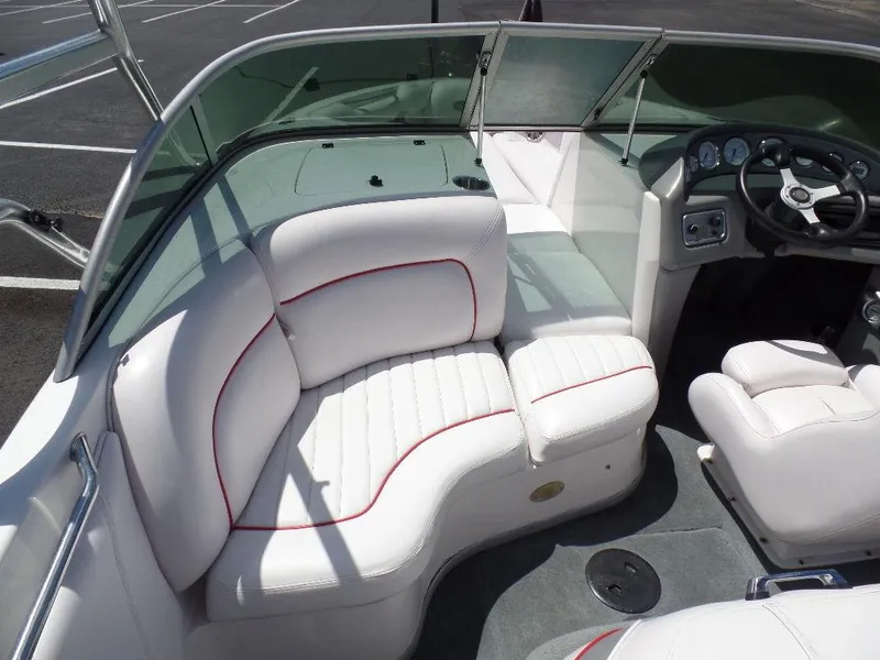 Slide: The Image of 2003 Supra 21 boat interior with white and red-trimmed seating. - 7