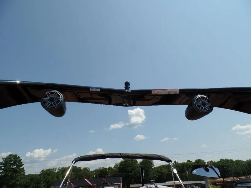 Slide: The Image of 2025 Harris Grand Mariner 250 boat speakers and canopy under clear sky. - 16