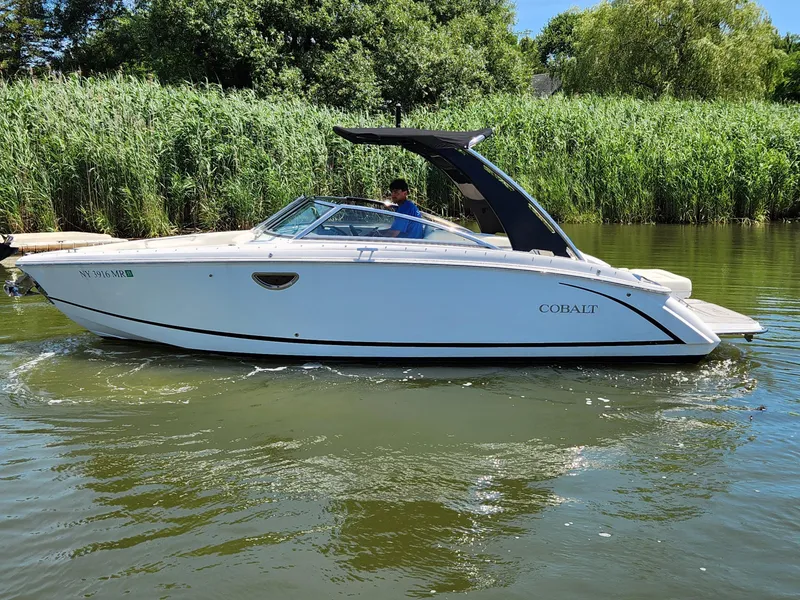 The Image of 2020 Cobalt R5 boat cruising on a calm river with lush greenery in the background. - 0
