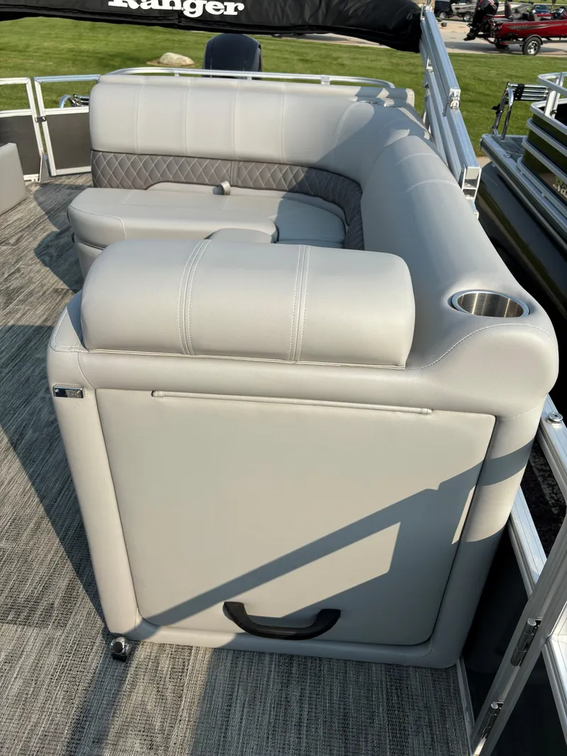 Slide: The Image of 2024 Ranger Reata 220F boat with gray cushioned seating and cup holder. - 16