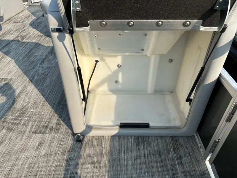 Slide: The Image of 2024 Ranger Reata 220F storage compartment with open lid on carpeted floor. - 17