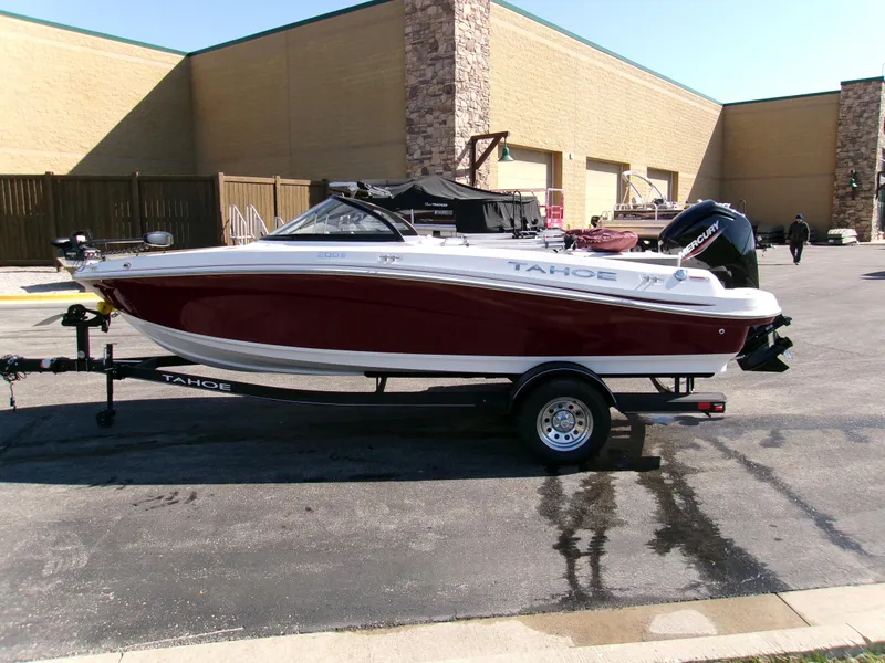 Slide: The Image of 2024 Tahoe 200 S boat on trailer, parked outdoors near a building. - 2