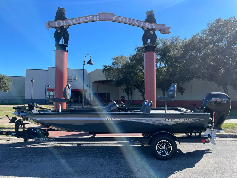Slide: The Image of 2024 Ranger RT198P boat parked outdoors under a decorative archway. - 0